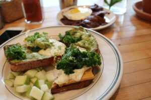 EGG SANDWICH of SCRAMBLED EGGS, CASHEW CHEESE, KALE, TOMATO JAM, and AVOCADO on GLUTEN FREE BREAD at The Butcher's Daughter
