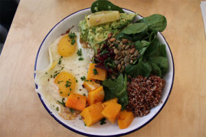 Salad with sunny side up eggs, avocado, quinoa, squash from Two Hands