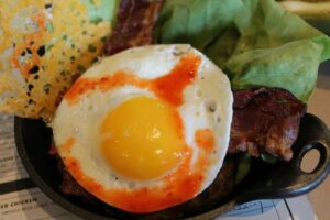Burger no bread with a sunny side up egg at Plan Check Kitchen + Bar