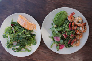 Oasis Salad with grilled shrimp and avocado and market greens salad with grilled salmon and avocado at King's Highway Diner